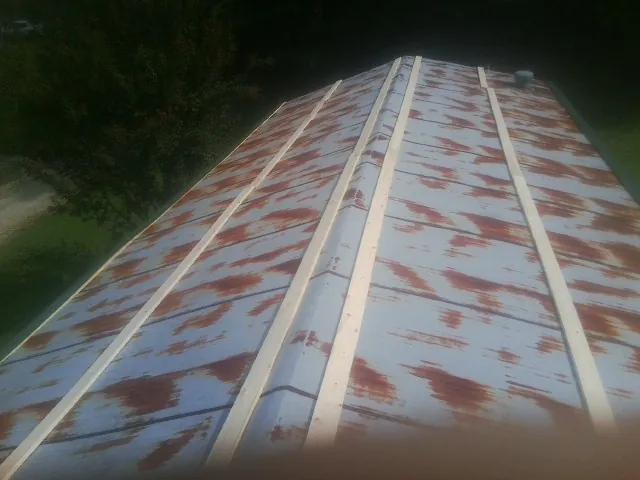 Rusted metal roof panels with new wood purlins before replacement — Storm Damage Roof Repair in South Ozone Park by Roofing Brothers