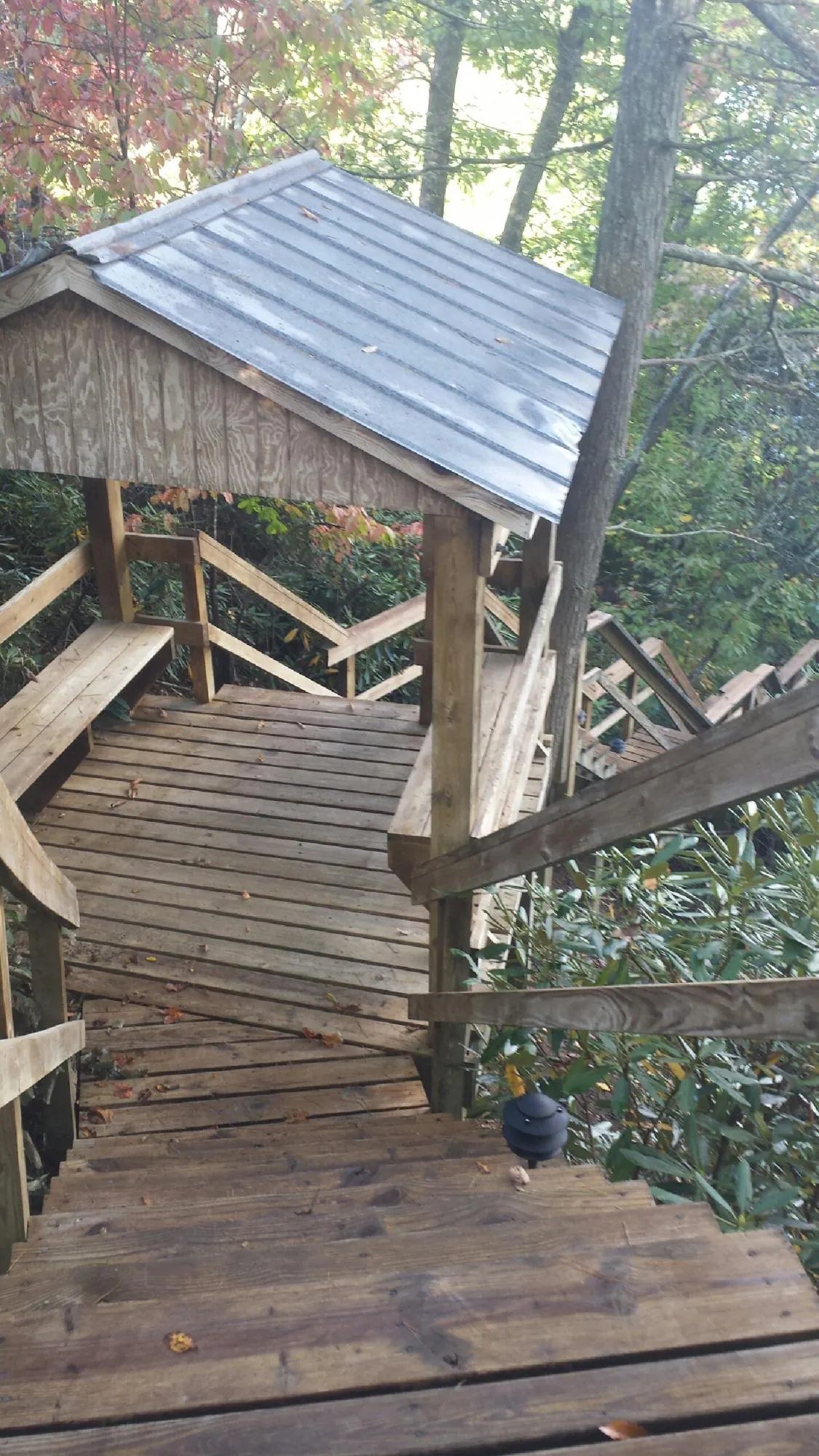 Metal roofed shelter over wooden steps on a wooded walkway — Skylight Repair & Installation work by our crew in South Ozone Park