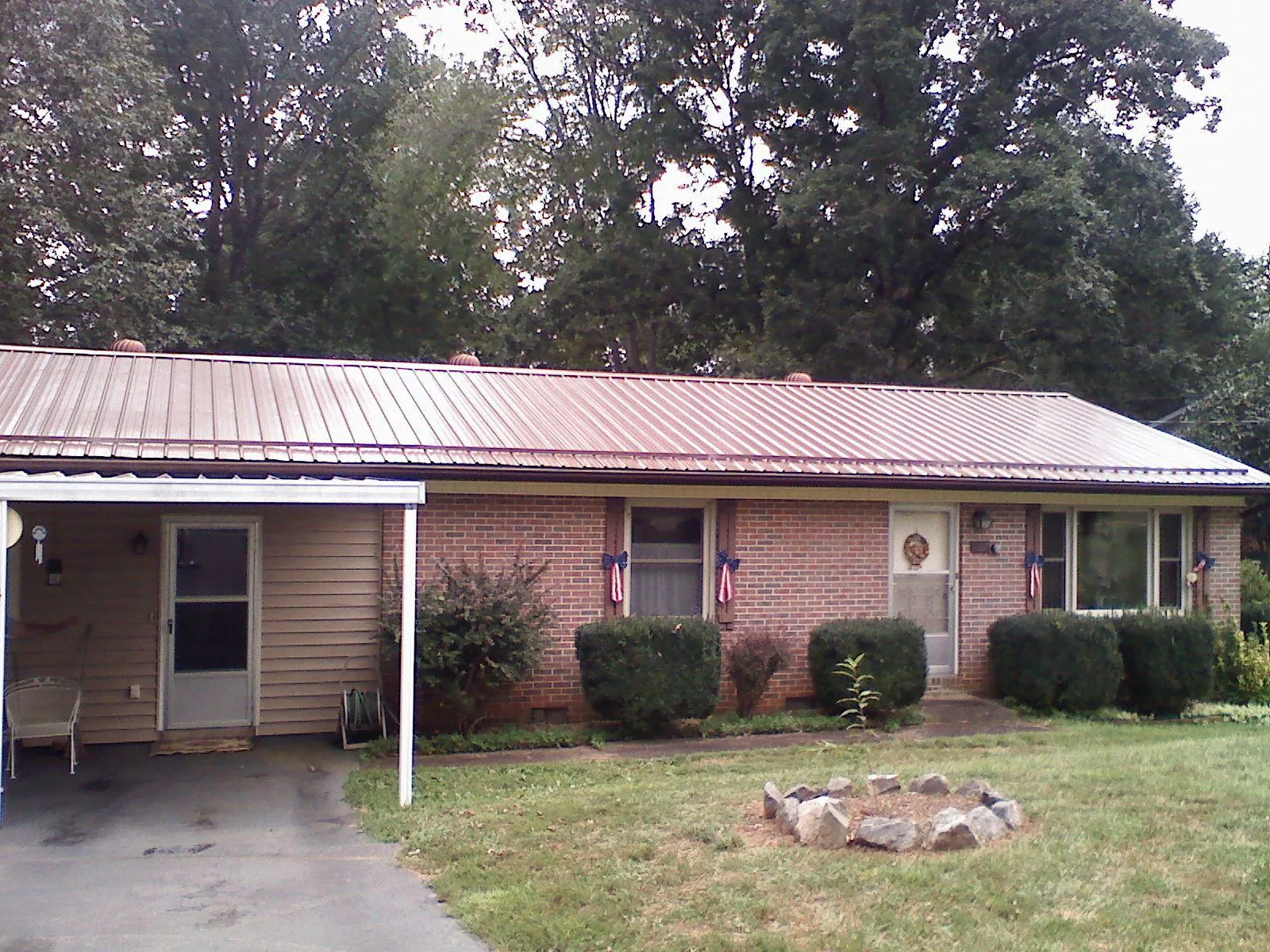 Bronze metal roof and carport on a brick ranch home — Roof Repair work by our crew in South Ozone Park